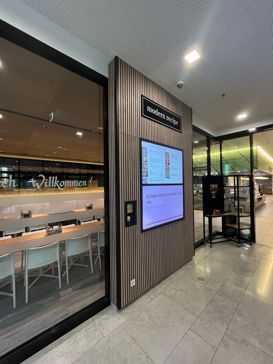 “modern recipe” menu-board pylon clad in slatted oak at the restaurant entrance